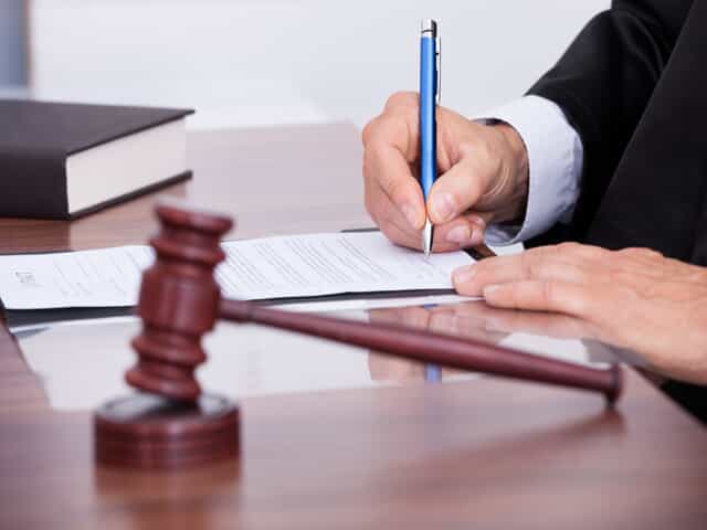 Gavel with judge signing document representing a divorce decree 